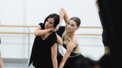 Choreographer in black partnering with dancer to show moves