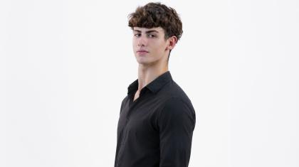 Male in black shirt, and dark, short, curly hair